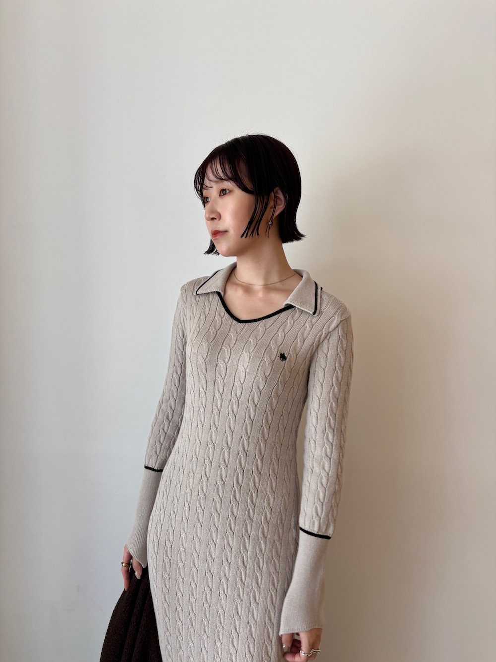 ベージュ系のワンピース、ブラウン系のブルゾン、ブラウン系のブーツを着用したレディースの秋コーディネートの5枚目の写真