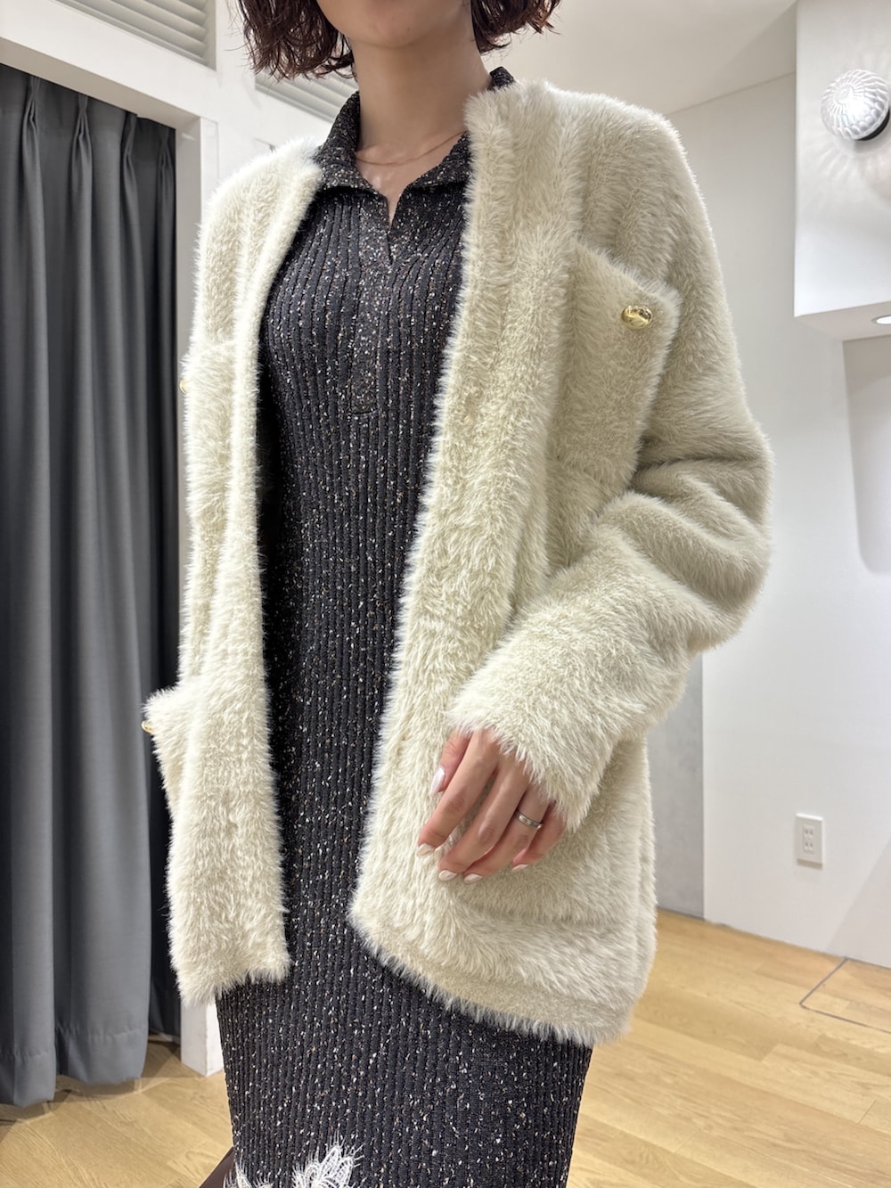 グレー系のワンピース、ブラウン系のハンドバッグ、ブラック系のブーツを着用したレディースの秋コーディネートの8枚目の写真