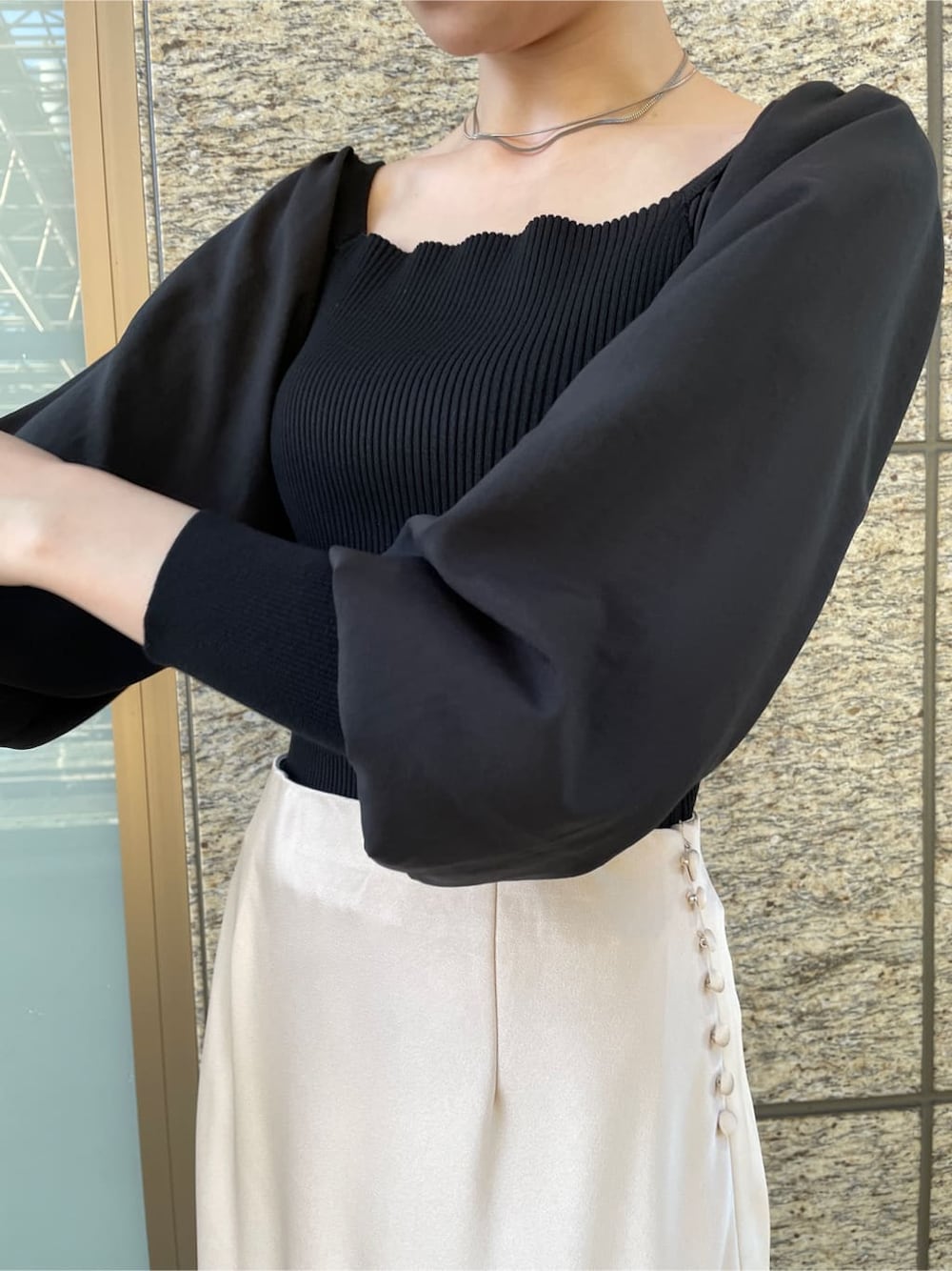 ホワイト系のスカート、ホワイト系のノーカラーコート、ブラック系のニット/セーターを着用したレディースの冬コーディネートの4枚目の写真