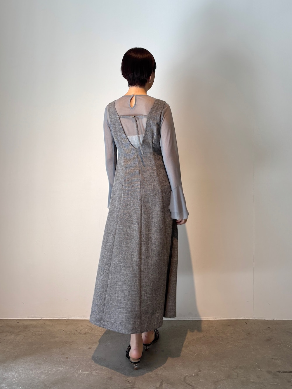グレー系のジャンパースカート、ブルー系のTシャツ/カットソー、ブラック系のサンダルを着用したレディースの春コーディネートの4枚目の写真