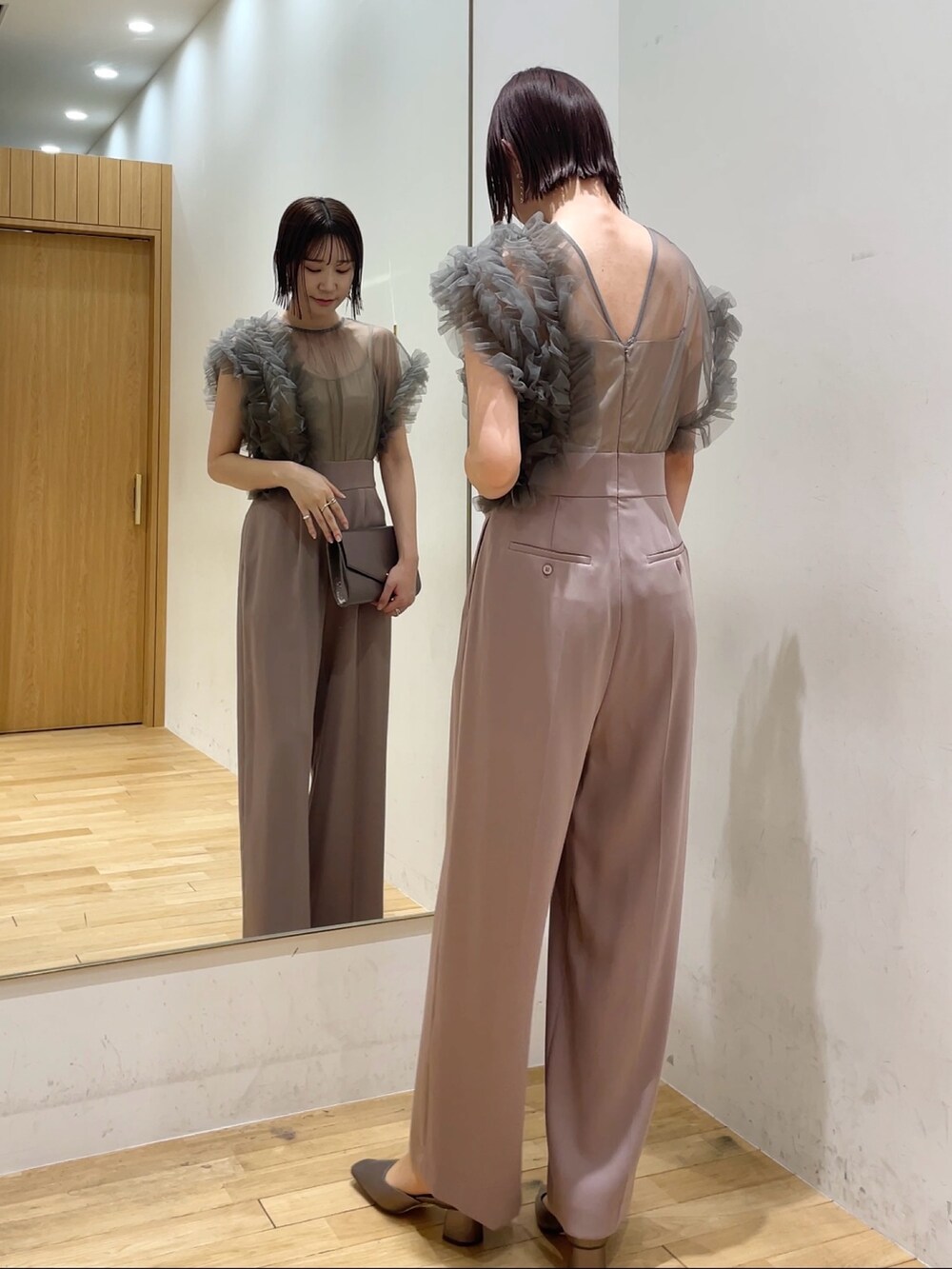 シルバー系のハンドバッグ、ピンク系のパンツドレス、その他のパンプスを着用したレディースの冬コーディネートの2枚目の写真