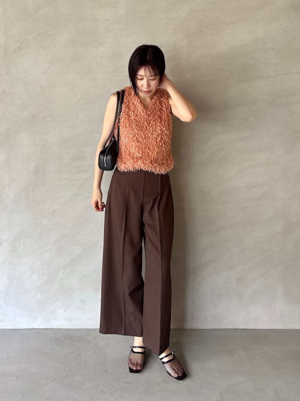 ブラウン系のその他パンツ、オレンジ系のTシャツ/カットソー、ブラック系のサンダルを着用したレディースの夏コーディネートの2枚目の写真