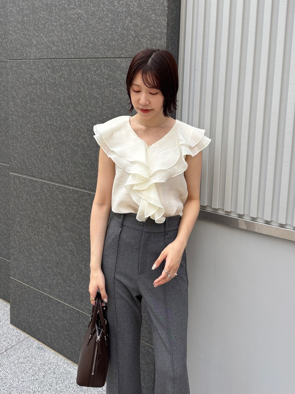 グレー系のその他パンツ、ホワイト系のシャツ/ブラウス、ブラウン系のボストンバッグを着用したレディースの夏コーディネートの4枚目の写真