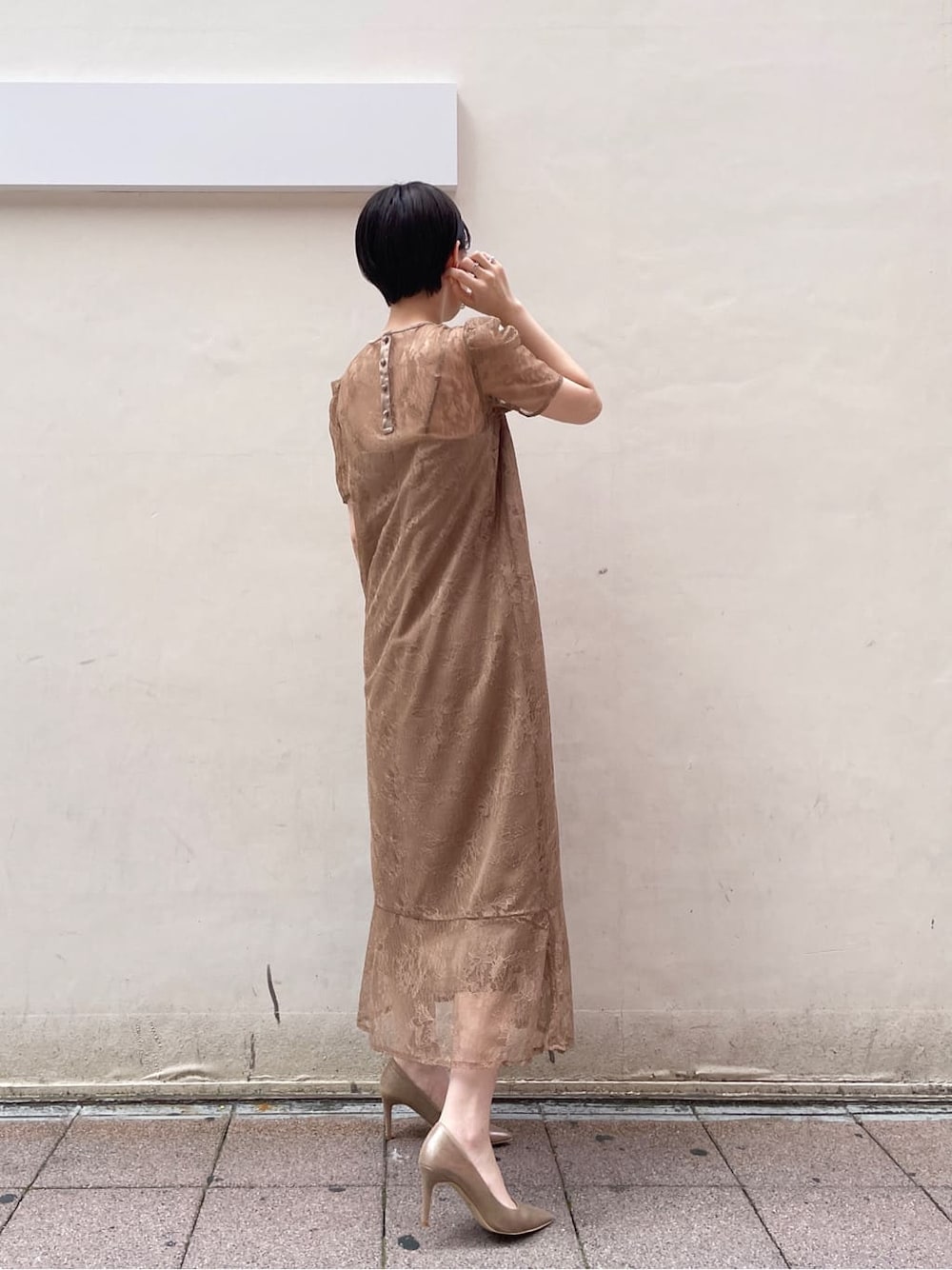 ゴールド系のパンプス、ゴールド系のクラッチバッグ、ベージュ系のドレスを着用したレディースの夏コーディネートの5枚目の写真