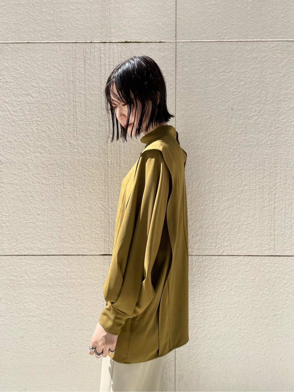 ホワイト系のスカート、ブラック系のその他シューズ、ベージュ系のその他アウターを着用したレディースの秋コーディネートの3枚目の写真