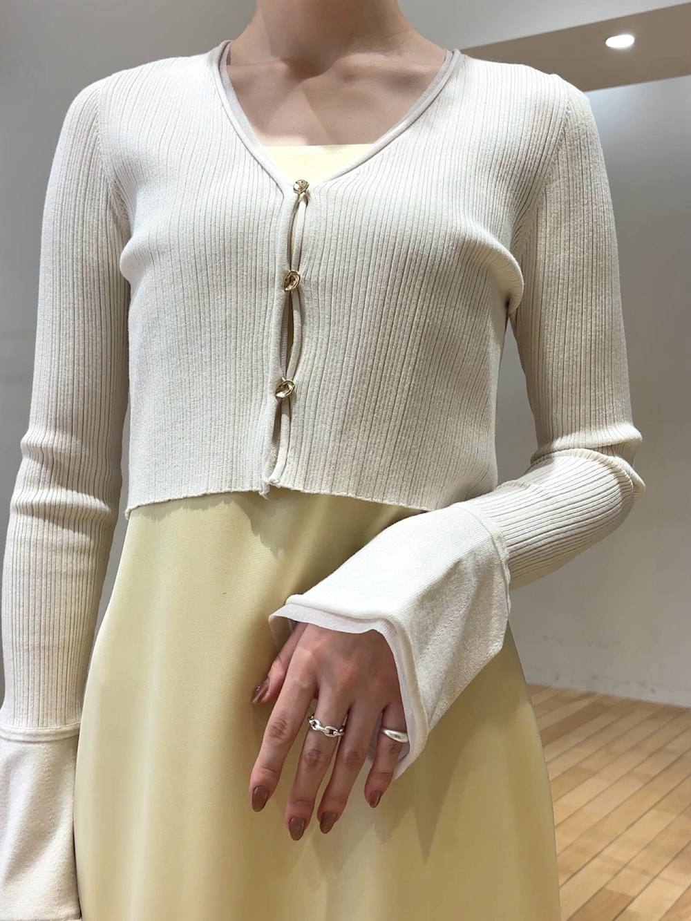 ホワイト系のワンピース、ホワイト系のサンダル、ブルー系のアンサンブルを着用したレディースの春コーディネートの5枚目の写真