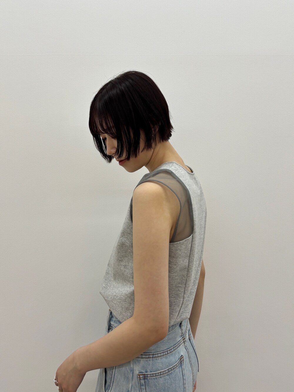 ブルー系のデニムパンツ、レッド系のサンダル、グレー系のTシャツ/カットソーを着用したレディースの春コーディネートの6枚目の写真