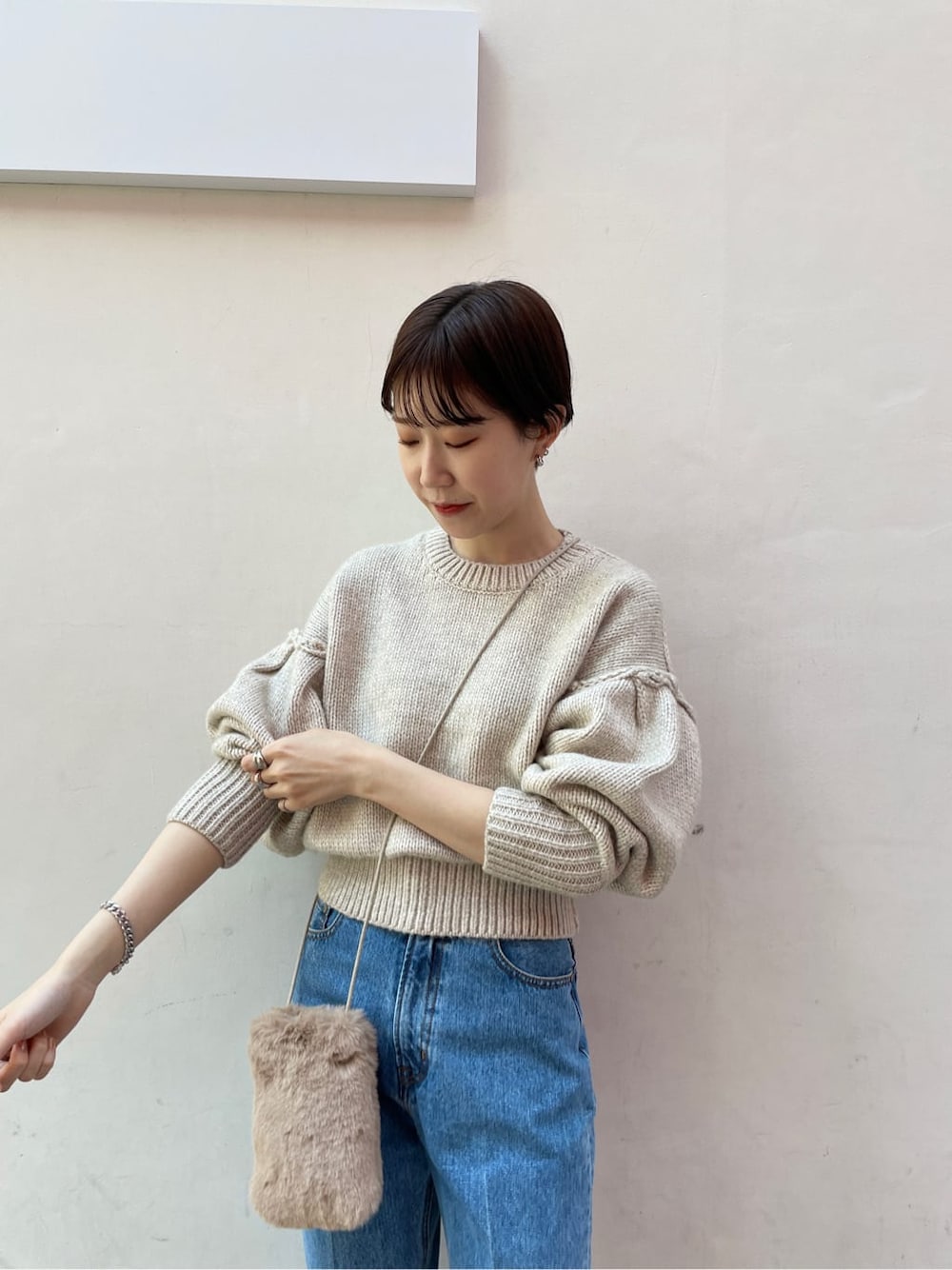 ブラック系のブーツ、ブルー系のデニムパンツ、ホワイト系のニット/セーターを着用したレディースの冬コーディネートの5枚目の写真