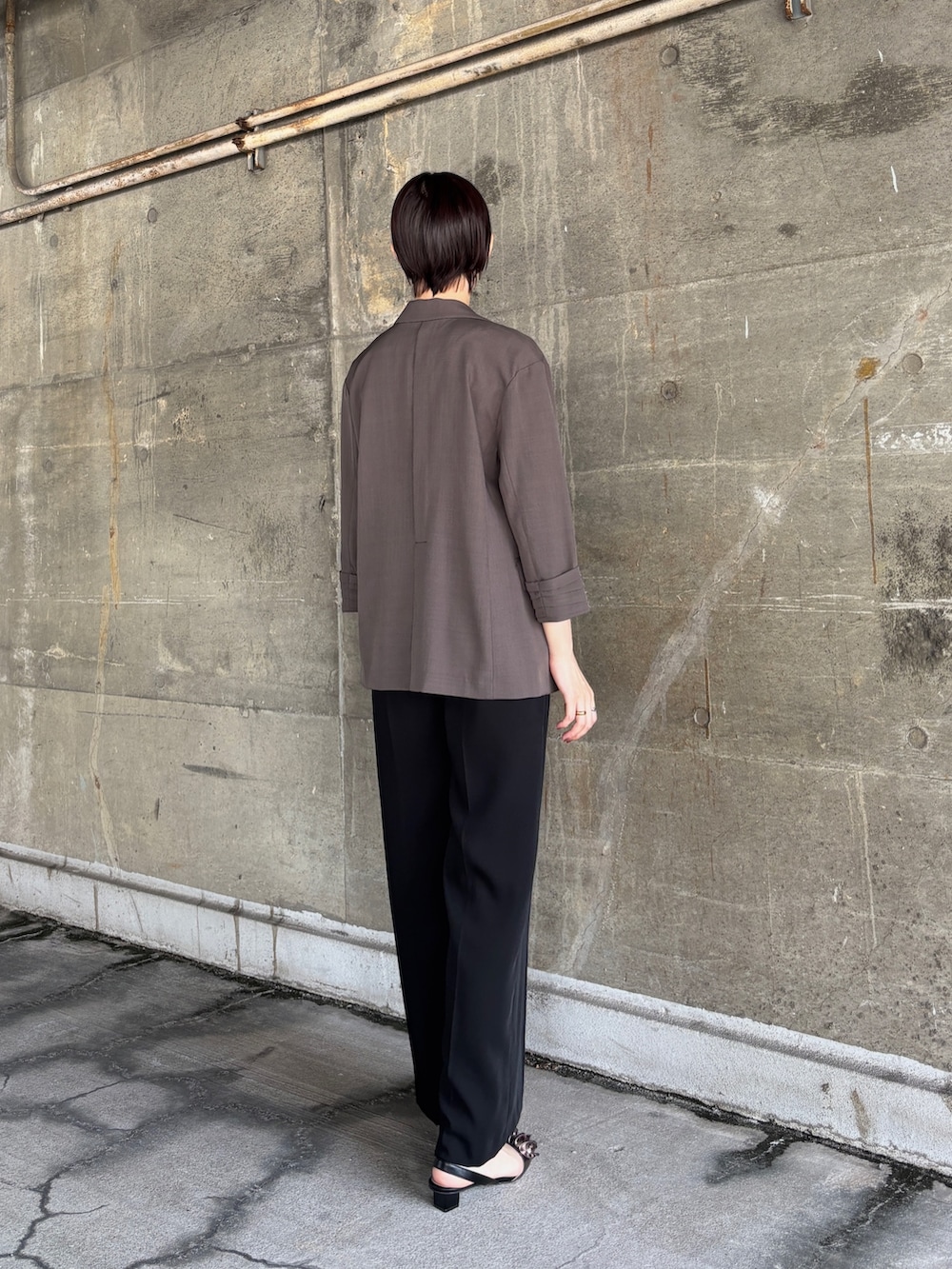 グレー系のテーラードジャケット、ブラック系のパンツドレス、その他のパンプスを着用したレディースの春コーディネートの4枚目の写真