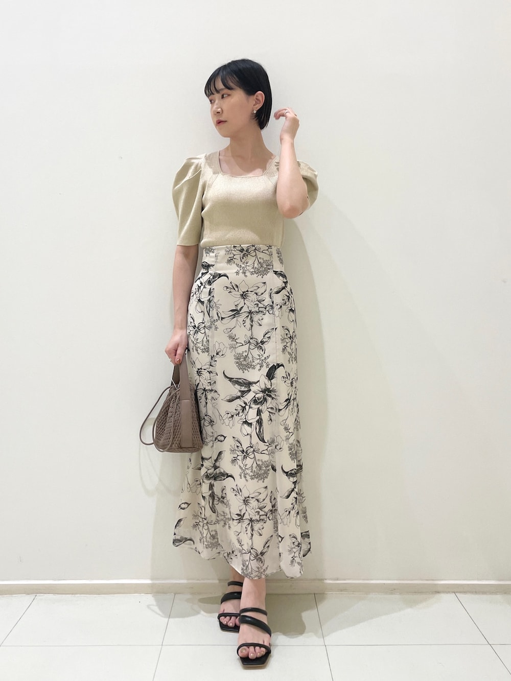 ブラウン系のテーラードジャケット、ベージュ系のニット/セーター、ホワイト系のスカートを着用したレディースの春コーディネートの7枚目の写真