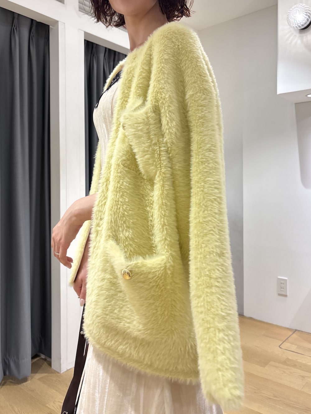 ホワイト系のワンピース、イエロー系のカーディガン/ボレロ、ブラウン系のハンドバッグを着用したレディースの秋コーディネートの6枚目の写真