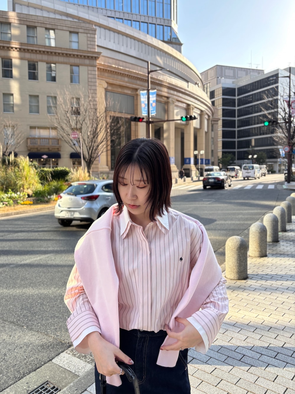 ピンク系のシャツ/ブラウス、ブルー系のデニムパンツ、ブラック系のハンドバッグを着用したレディースの春コーディネートの4枚目の写真