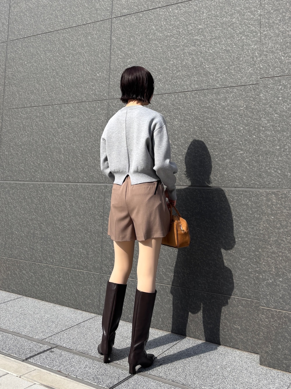 ブラウン系のその他パンツ、グレー系のカーディガン/ボレロ、イエロー系のハンドバッグを着用したレディースの冬コーディネートの4枚目の写真