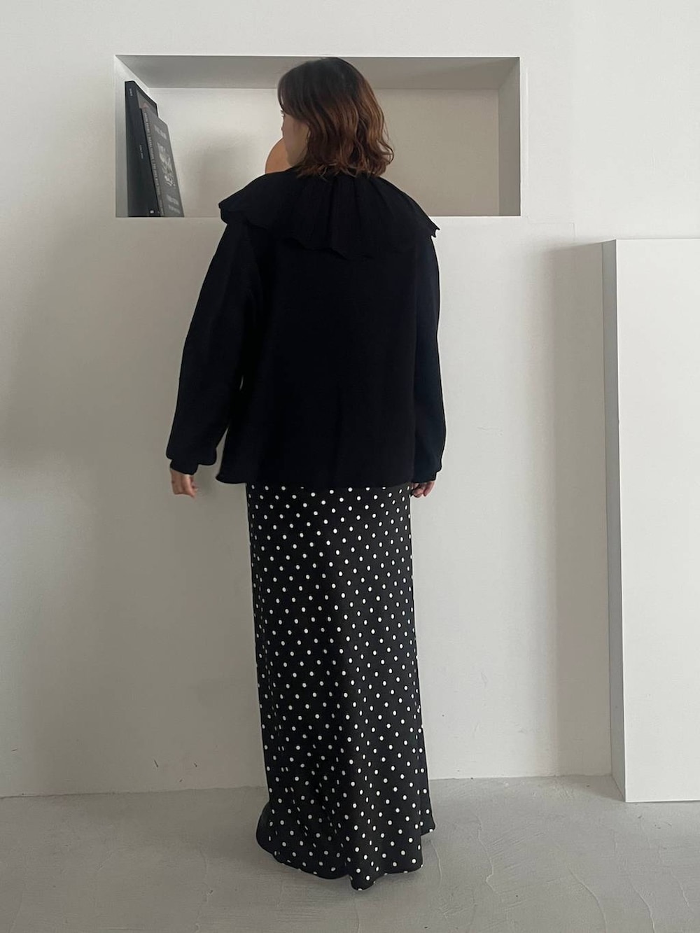 ブラック系のスカート、ブラック系のサンダル、ブラック系のニット/セーターを着用したレディースの秋コーディネートの3枚目の写真