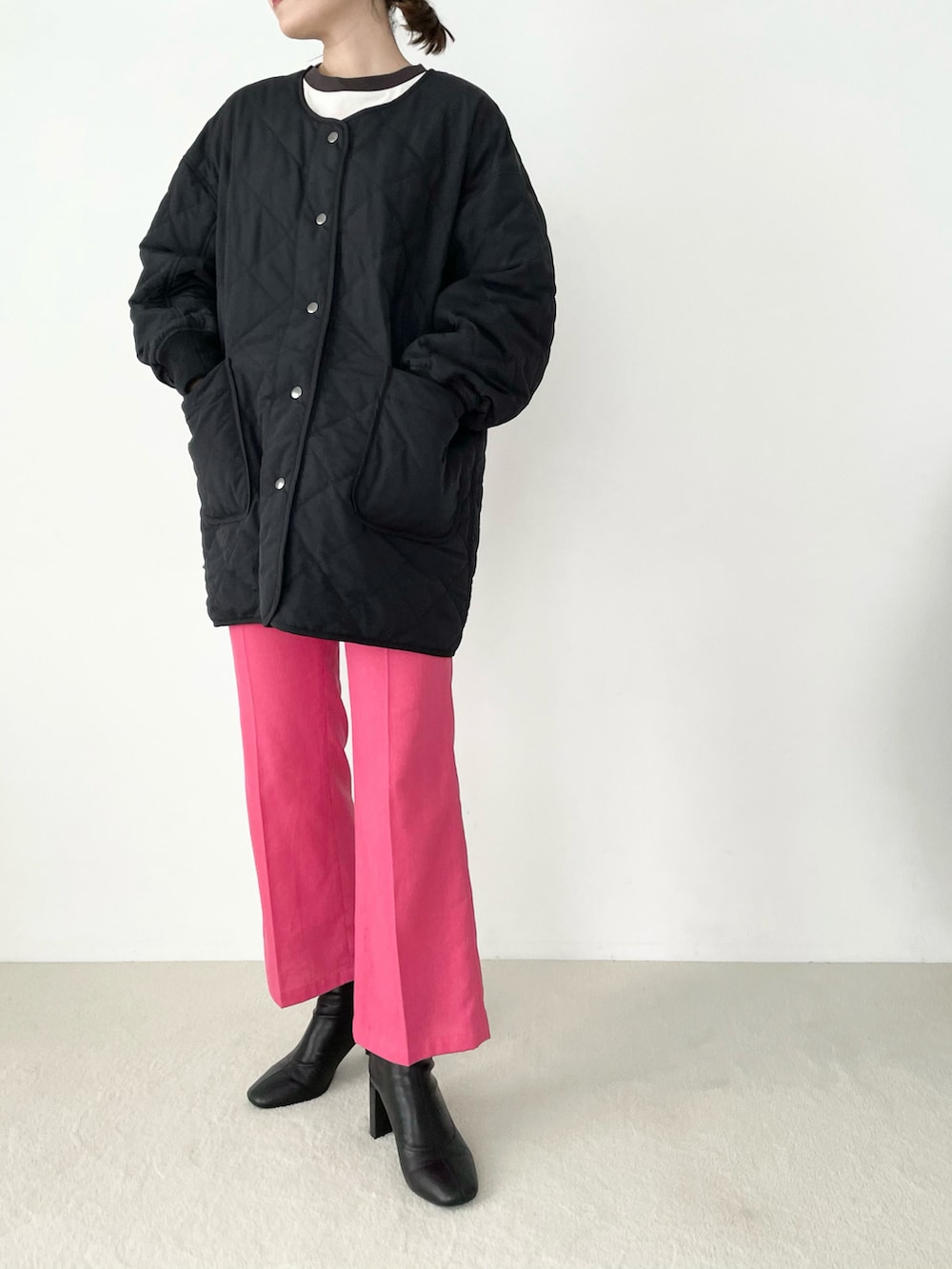 ブラック系のブルゾン、ピンク系のスラックス、ブラック系のブーツを着用したレディースの夏コーディネートの3枚目の写真