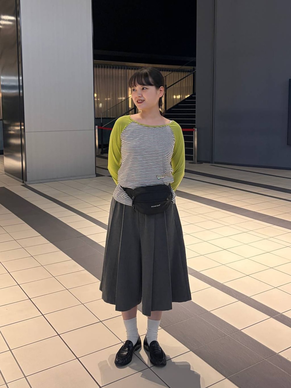 グレー系のスラックスを着用したレディースの秋コーディネートの2枚目の写真