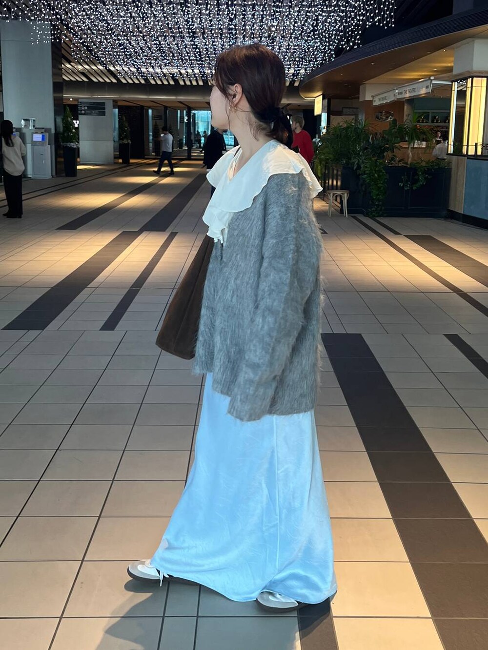 ブルー系のスカート、グレー系のカーディガン/ボレロを着用したレディースの秋コーディネートの2枚目の写真