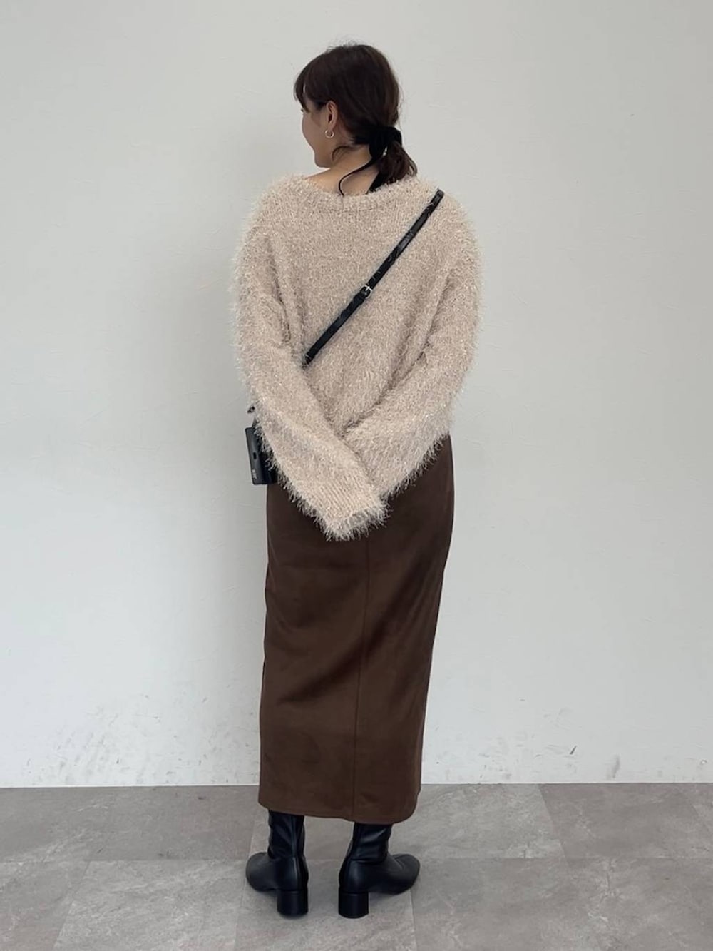 ブラック系のブーツ、ブラウン系のスカート、ベージュ系のカーディガン/ボレロを着用したレディースの秋コーディネートの3枚目の写真