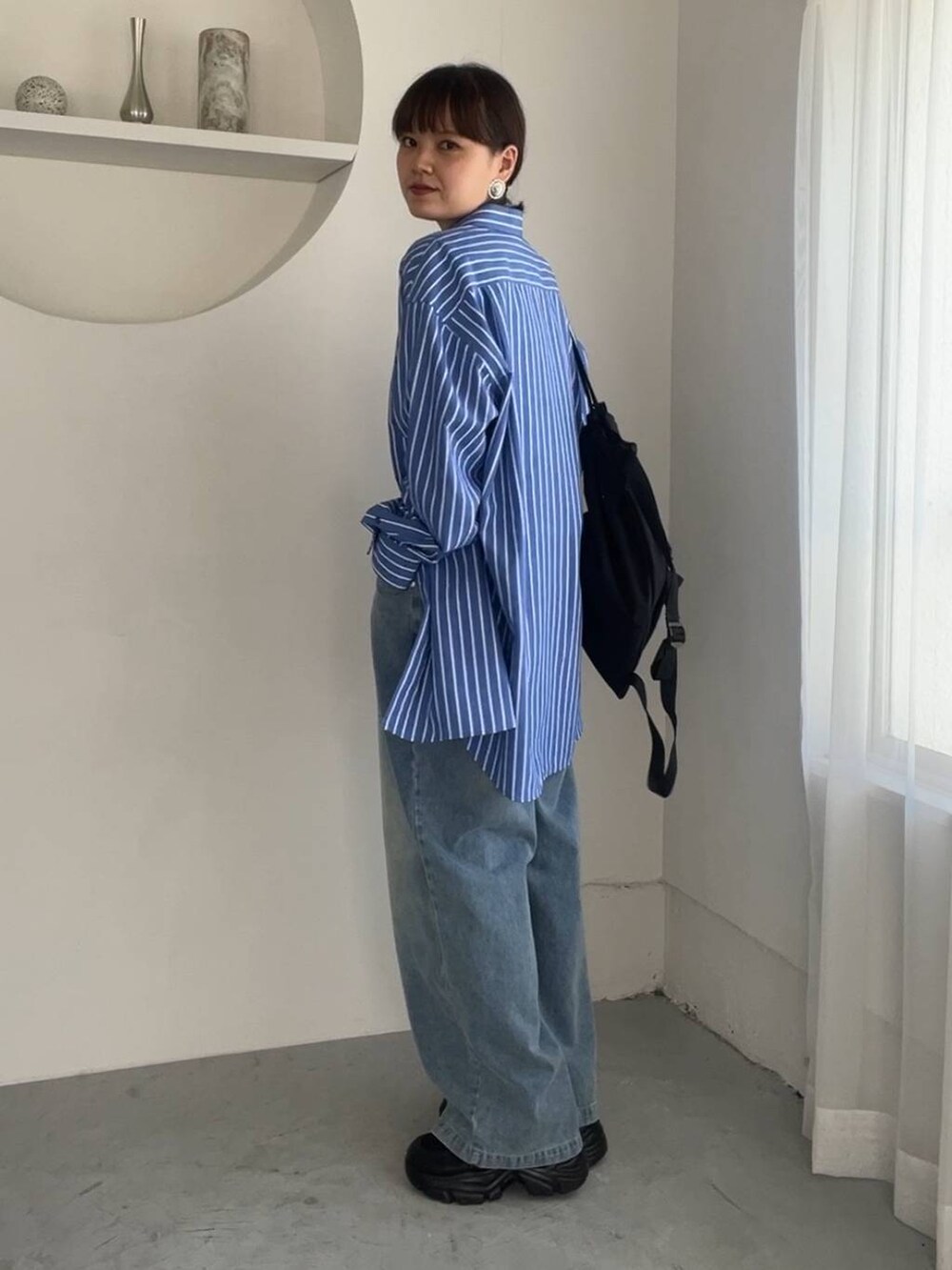 ブルー系のシャツ/ブラウス、ブルー系のデニムパンツ、ブラック系のスニーカーを着用したレディースの夏コーディネートの2枚目の写真