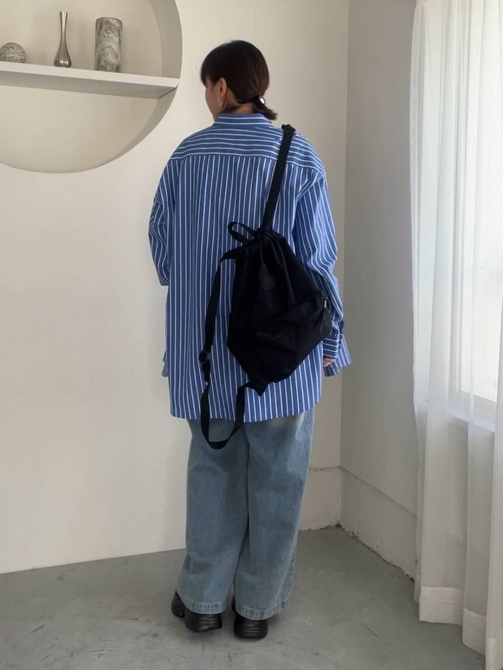 ブルー系のシャツ/ブラウス、ブルー系のデニムパンツ、ブラック系のスニーカーを着用したレディースの夏コーディネートの3枚目の写真