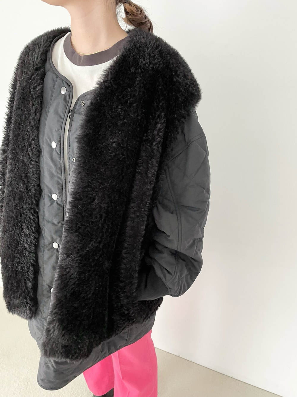 ブラック系のブルゾン、ピンク系のスラックス、ブラック系のブーツを着用したレディースの夏コーディネートの2枚目の写真