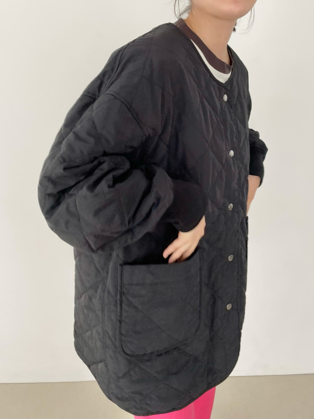 ブラック系のブルゾン、ピンク系のスラックス、ブラック系のブーツを着用したレディースの夏コーディネートの4枚目の写真