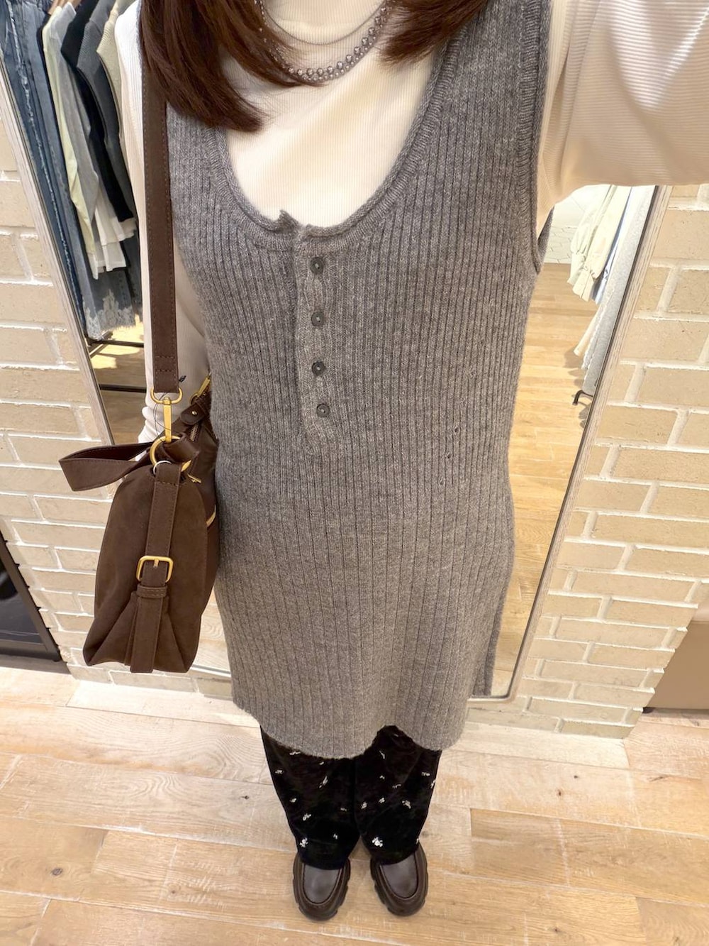 ブラウン系のハンドバッグ、ブラック系のその他パンツ、グレー系のチュニックを着用したレディースの秋コーディネートの2枚目の写真
