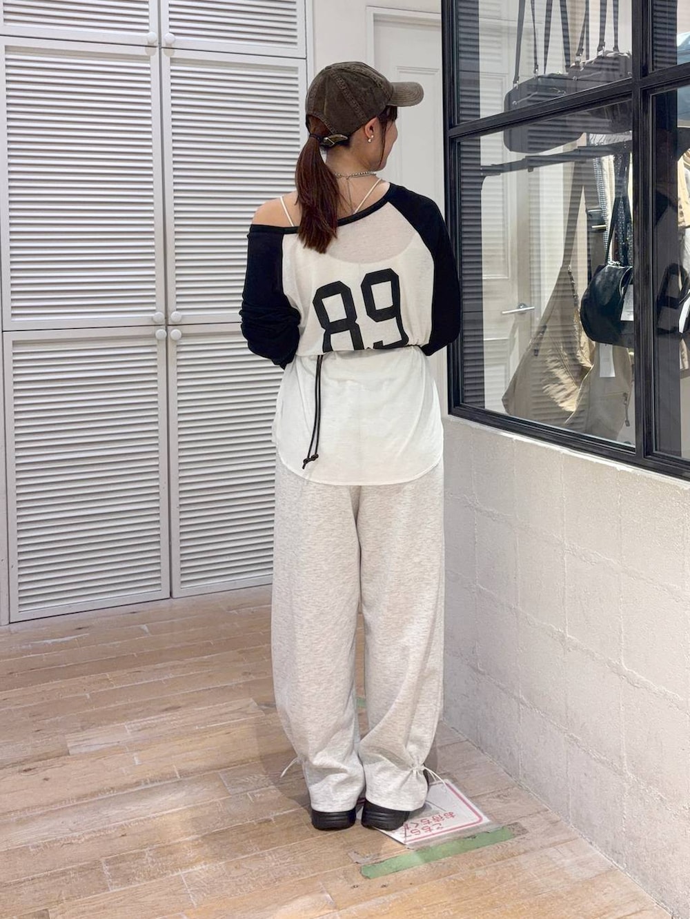 グレー系のスウェットパンツ、ブラック系のボディバッグ/ウエストポーチ、ホワイト系のTシャツ/カットソーを着用したレディースの夏コーディネートの3枚目の写真