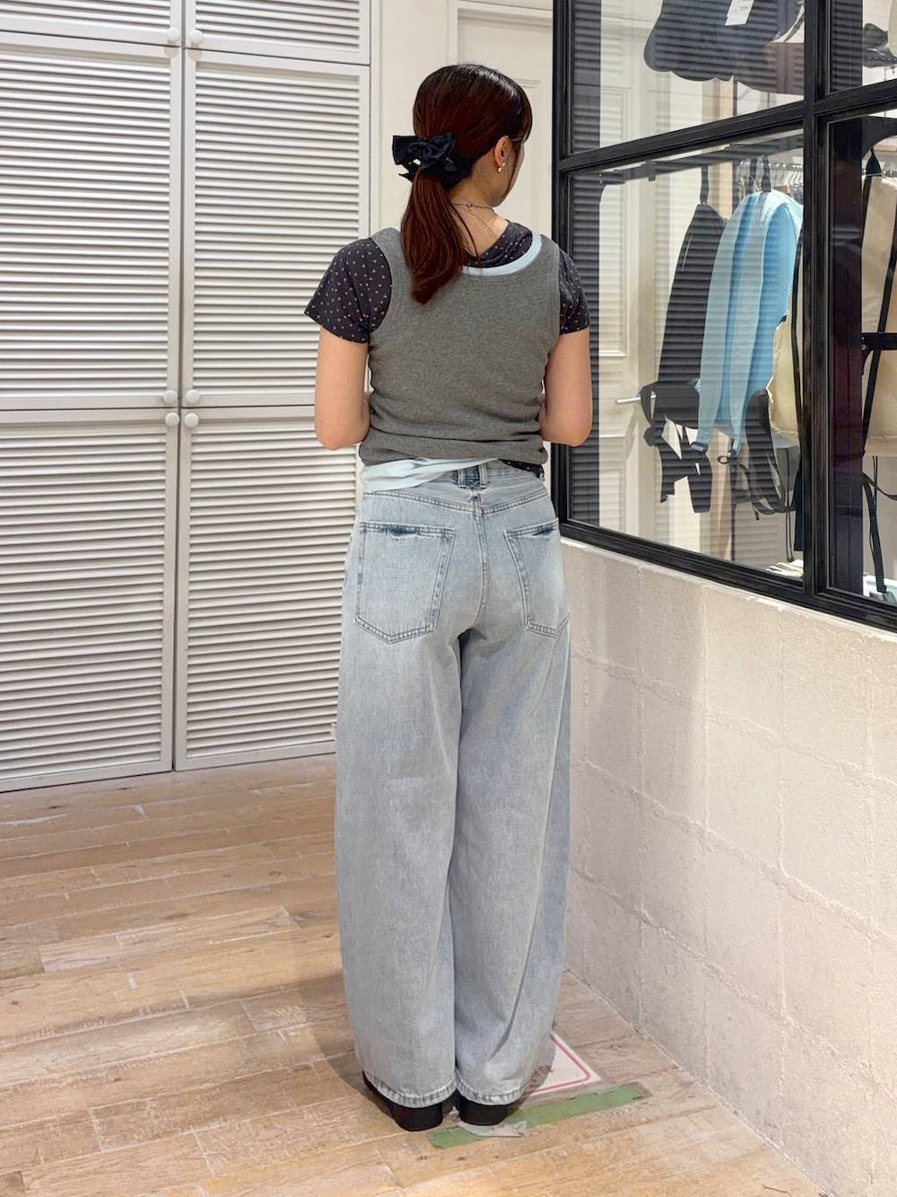 ブルー系のタンクトップ、グレー系のタンクトップ、ブルー系のデニムパンツを着用したレディースの夏コーディネートの3枚目の写真