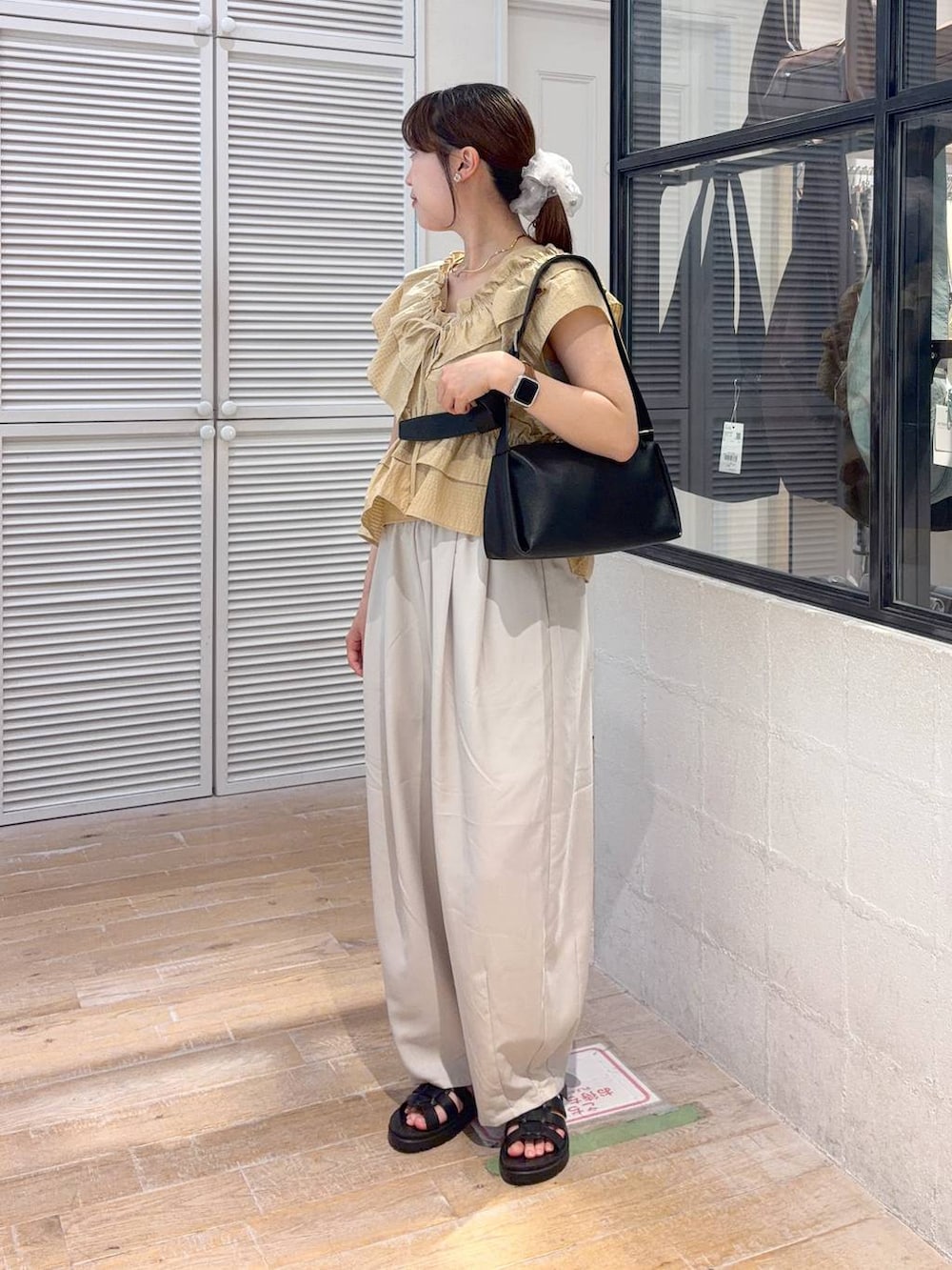 ブラウン系のその他パンツ、ブラウン系のサンダル、ブラック系のショルダーバッグを着用したレディースの夏コーディネートの2枚目の写真