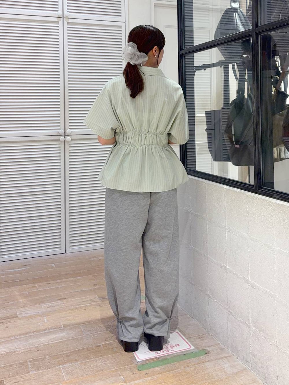グレー系のスウェットパンツ、ブラック系のサンダル、グリーン系のTシャツ/カットソーを着用したレディースの夏コーディネートの3枚目の写真