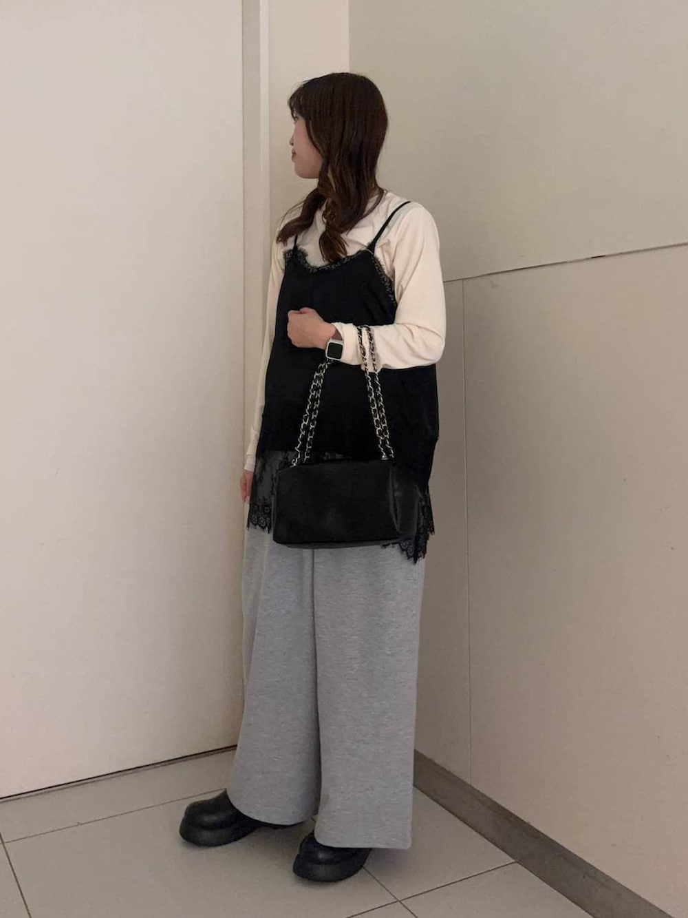 ブラック系のショルダーバッグ、ブラック系のサンダル、グレー系のスウェットパンツを着用したレディースの春コーディネートの2枚目の写真