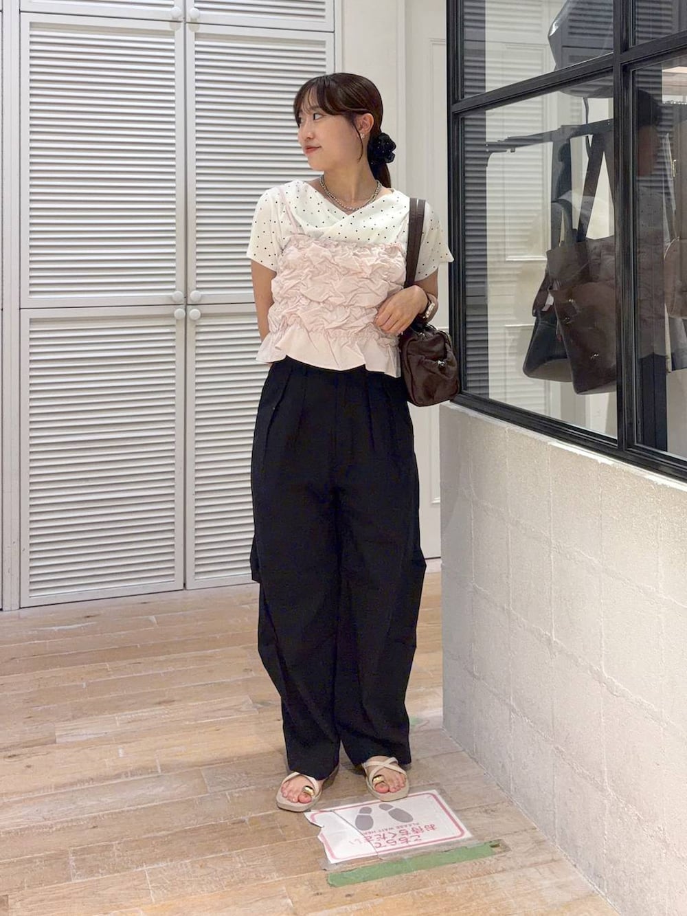 ピンク系のベスト、ブラック系のその他パンツ、ベージュ系のTシャツ/カットソーを着用したレディースの夏コーディネートの2枚目の写真