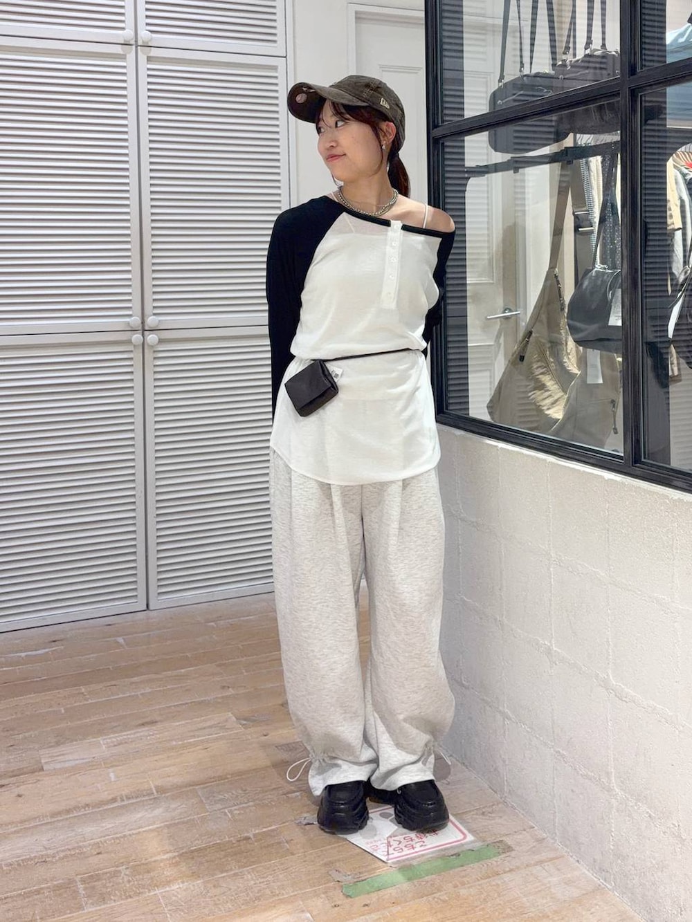 グレー系のスウェットパンツ、ブラック系のボディバッグ/ウエストポーチ、ホワイト系のTシャツ/カットソーを着用したレディースの夏コーディネートの2枚目の写真