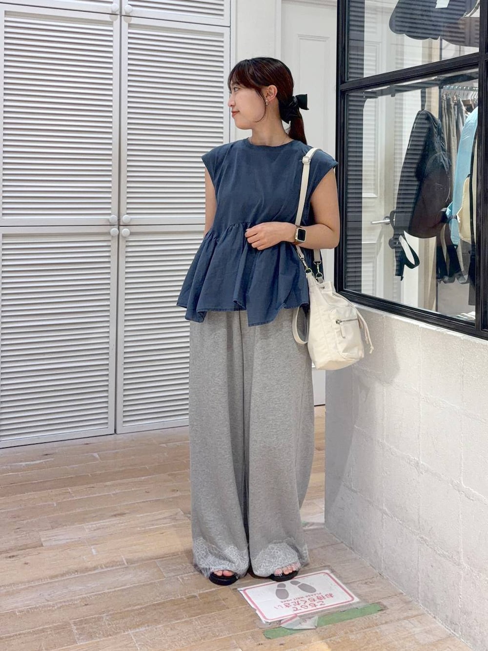 ブルー系のTシャツ/カットソー、ブラック系のサンダル、グレー系のスウェットパンツを着用したレディースの夏コーディネートの2枚目の写真