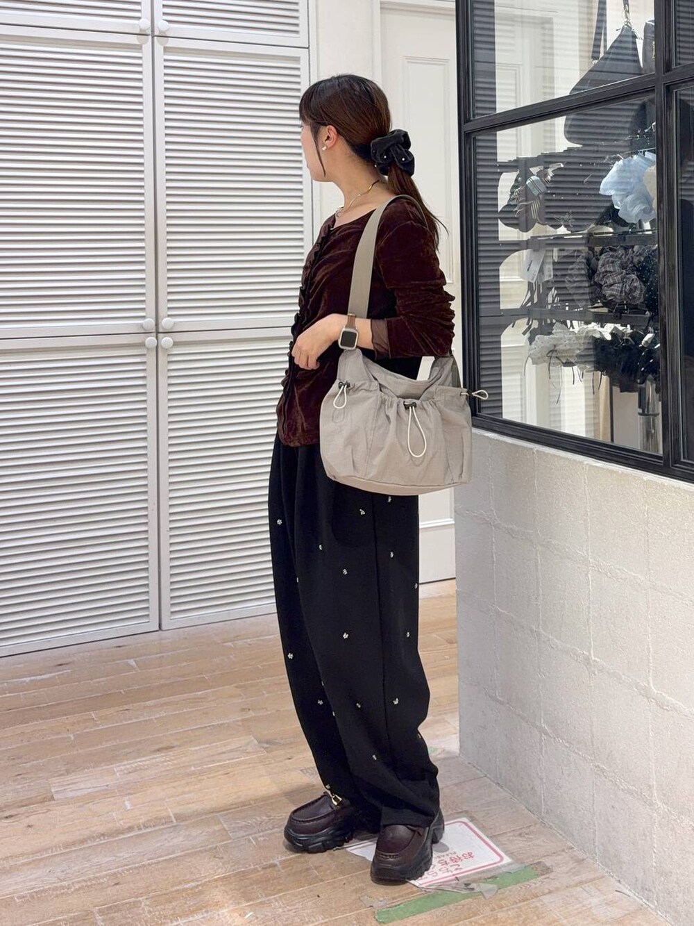 グレー系のショルダーバッグ、ブラック系のスウェットパンツ、ブラウン系のTシャツ/カットソーを着用したレディースの秋コーディネートの2枚目の写真
