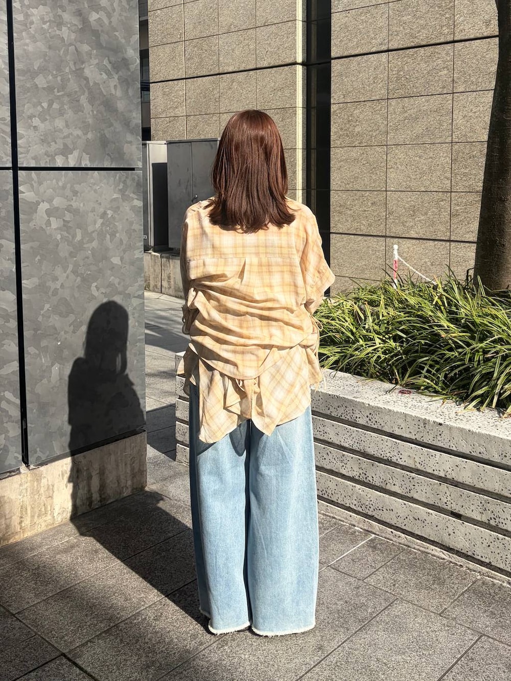 ホワイト系のショルダーバッグ、ブルー系のデニムパンツ、ブラック系のサンダルを着用したレディースの春コーディネートの3枚目の写真