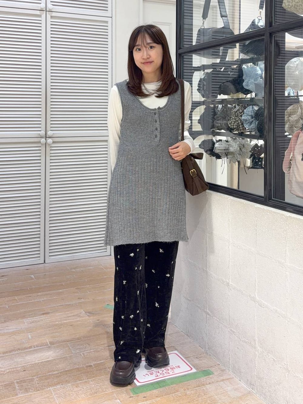 ブラウン系のハンドバッグ、ブラック系のその他パンツ、グレー系のチュニックを着用したレディースの秋コーディネートの3枚目の写真