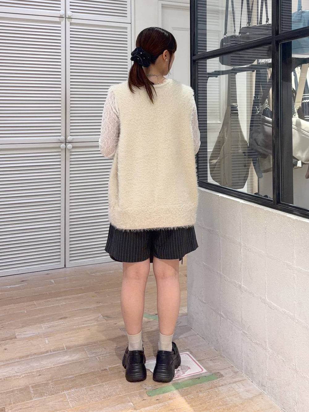 ホワイト系のTシャツ/カットソー、ブラウン系のショルダーバッグ、ホワイト系のベストを着用したレディースの秋コーディネートの3枚目の写真