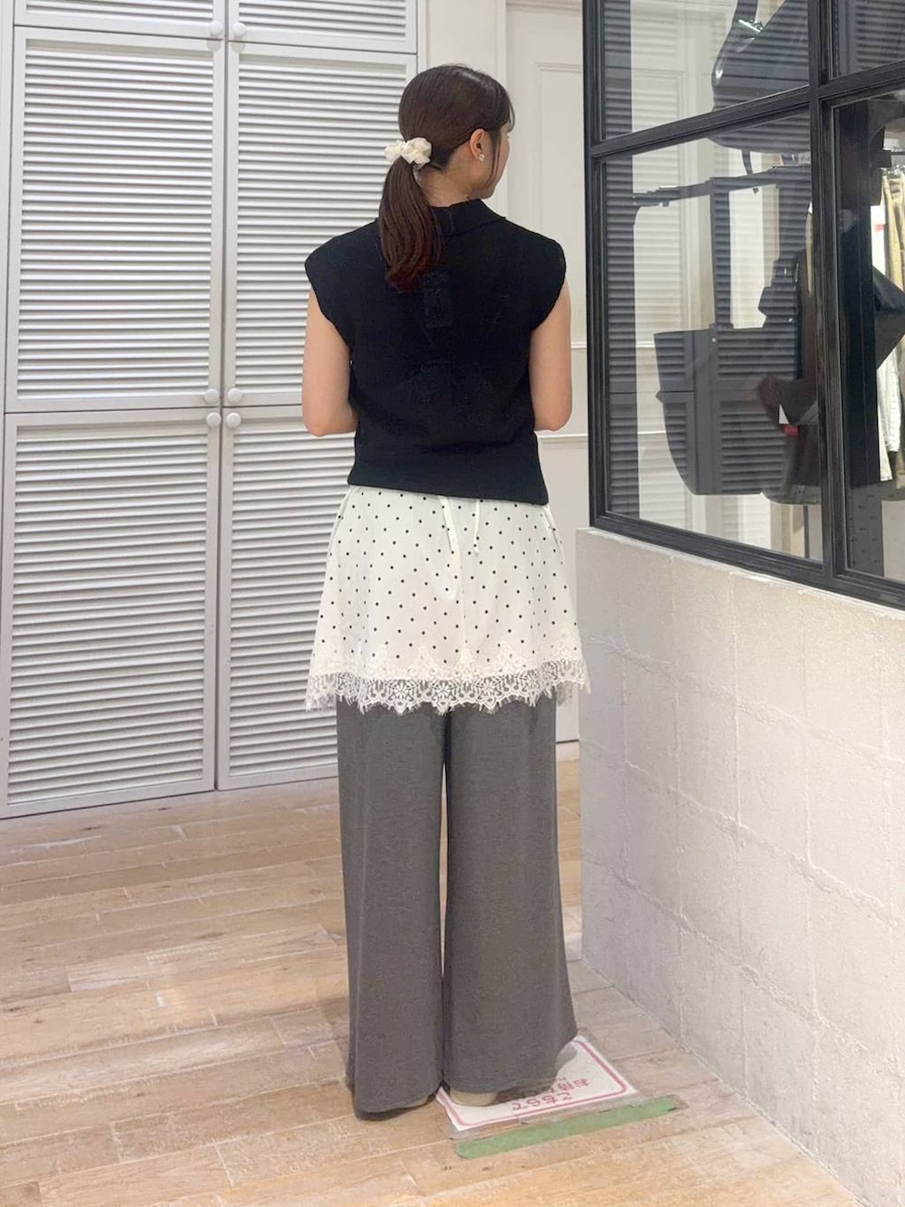 ブラック系のベスト、グレー系のその他パンツ、ホワイト系のサンダルを着用したレディースの夏コーディネートの3枚目の写真