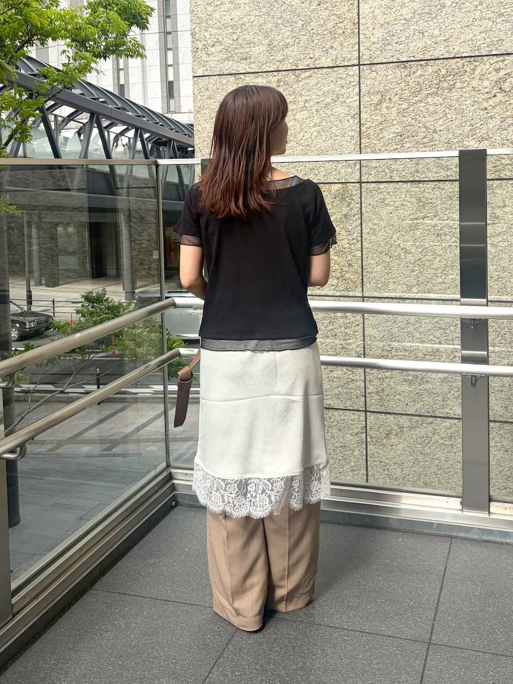 ベージュ系のスラックス、ブラウン系のサンダル、ブラウン系のショルダーバッグを着用したレディースの春コーディネートの4枚目の写真