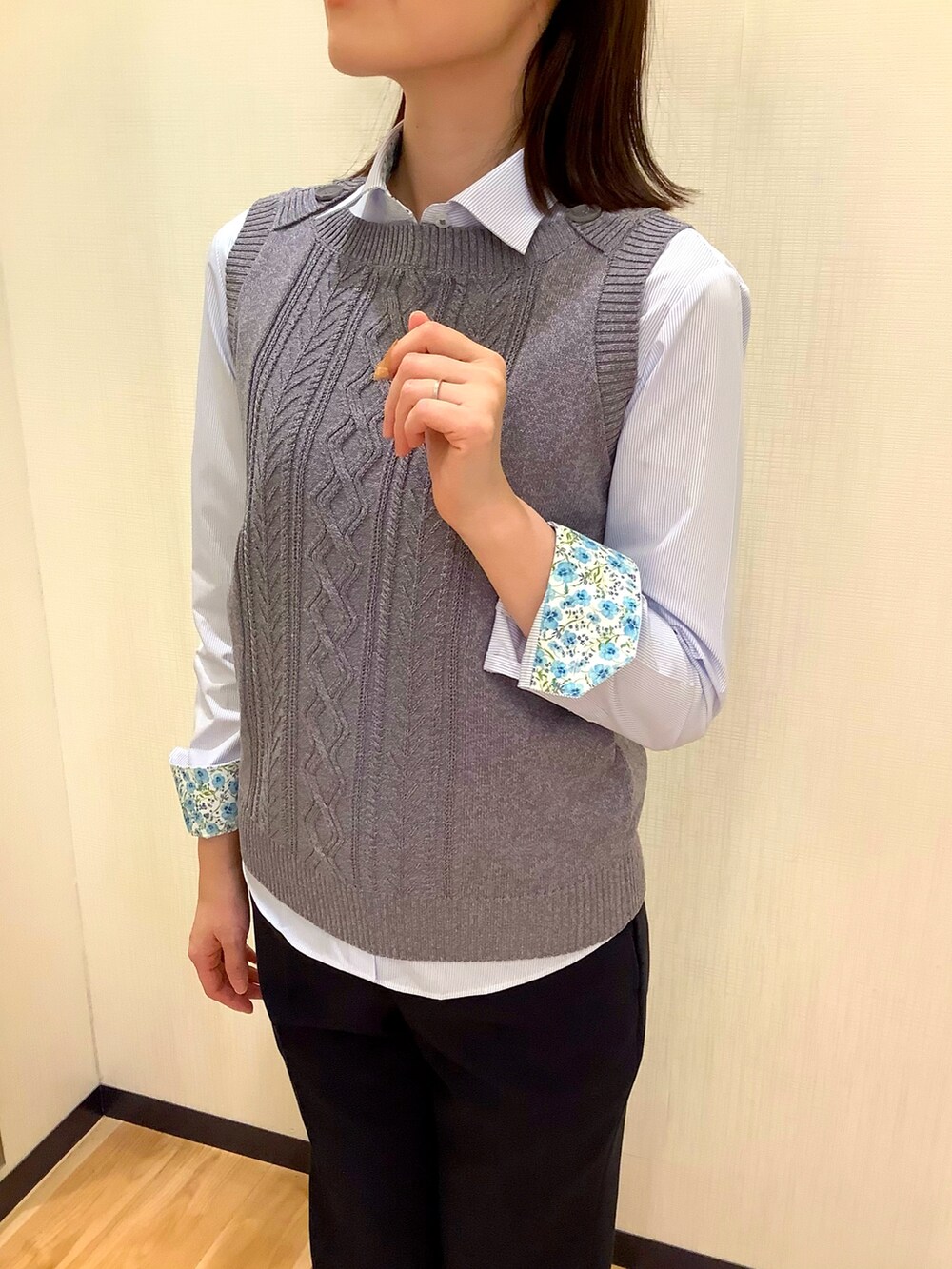 グレー系のベスト、ブルー系のビジネスシャツを着用したレディースの冬コーディネートの2枚目の写真