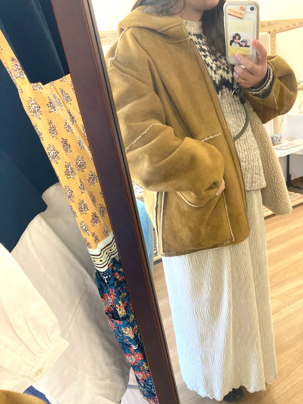 ホワイト系のスカート、ブラック系のモカシン/デッキシューズを着用したレディースの冬コーディネートの2枚目の写真