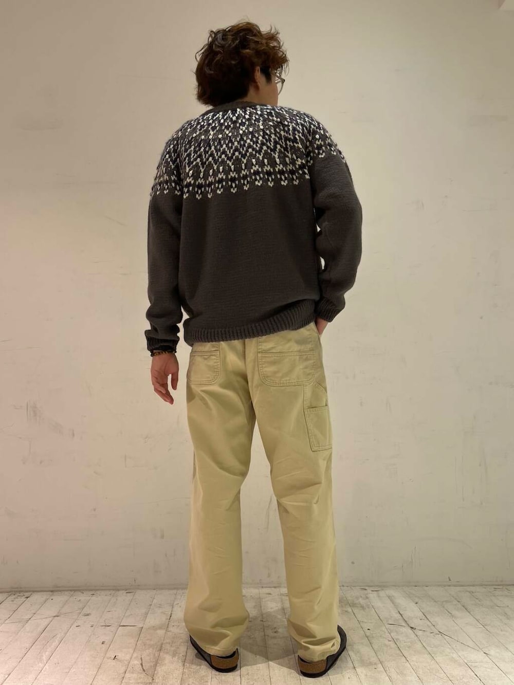 ブラウン系のニット/セーター、ベージュ系のその他パンツ、グレー系のサンダルを着用したメンズの秋コーディネートの2枚目の写真