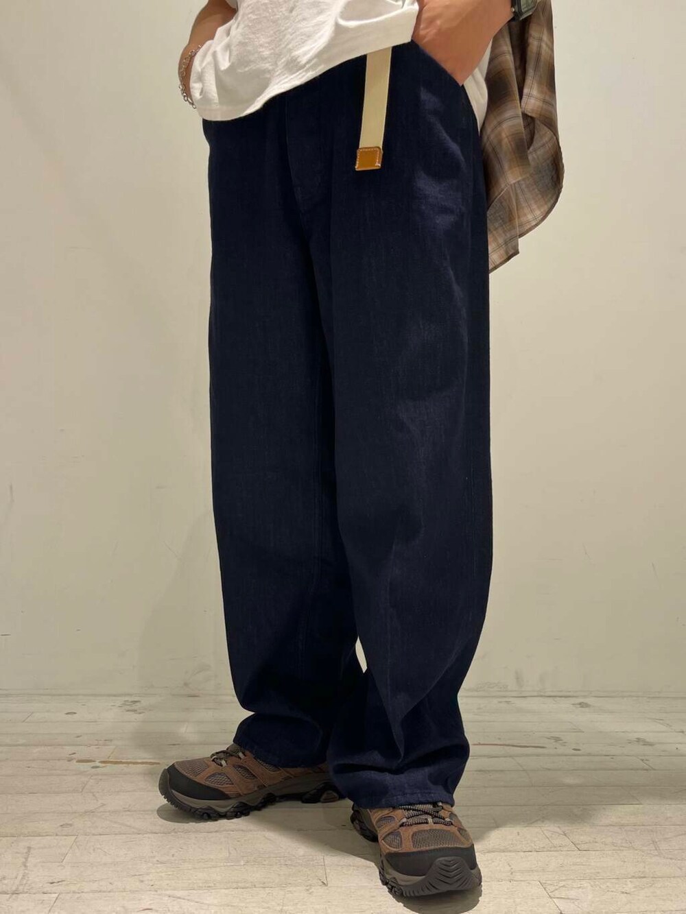 ブルー系のデニムパンツ、ブラウン系のスニーカー、ホワイト系のTシャツ/カットソーを着用したメンズの秋コーディネートの6枚目の写真