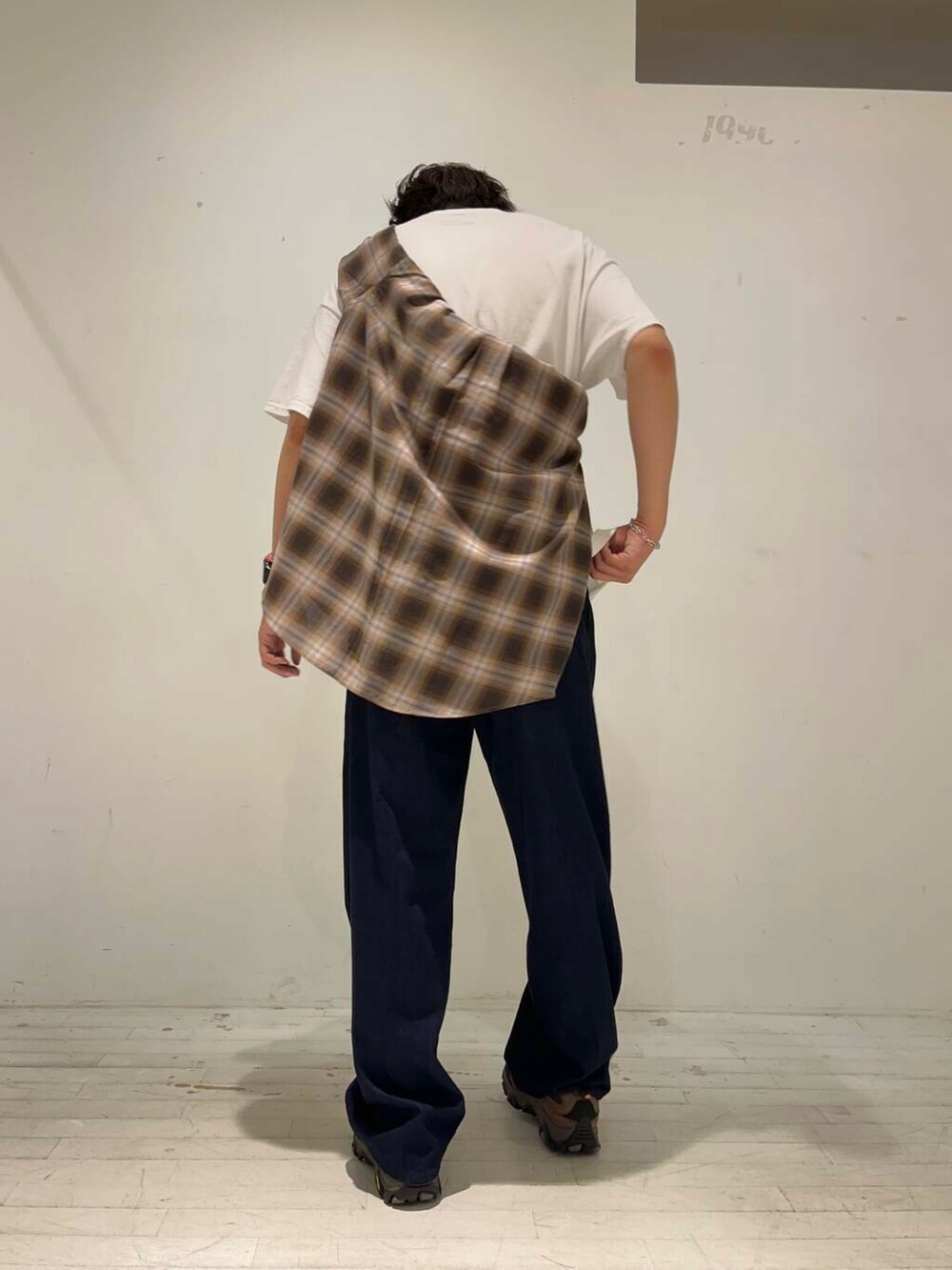 ブルー系のデニムパンツ、ブラウン系のスニーカー、ホワイト系のTシャツ/カットソーを着用したメンズの秋コーディネートの3枚目の写真