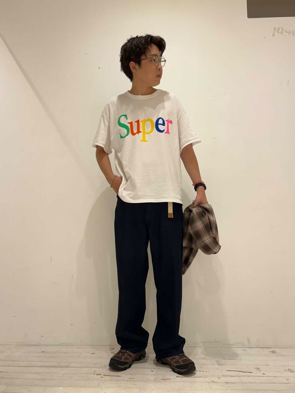 ブルー系のデニムパンツ、ブラウン系のスニーカー、ホワイト系のTシャツ/カットソーを着用したメンズの秋コーディネートの4枚目の写真