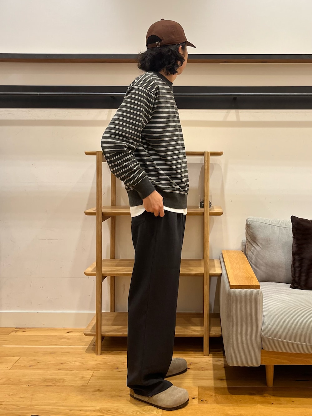 グレー系のニット/セーター、ブラウン系のその他パンツ、ベージュ系のサンダルを着用したメンズの秋コーディネートの2枚目の写真