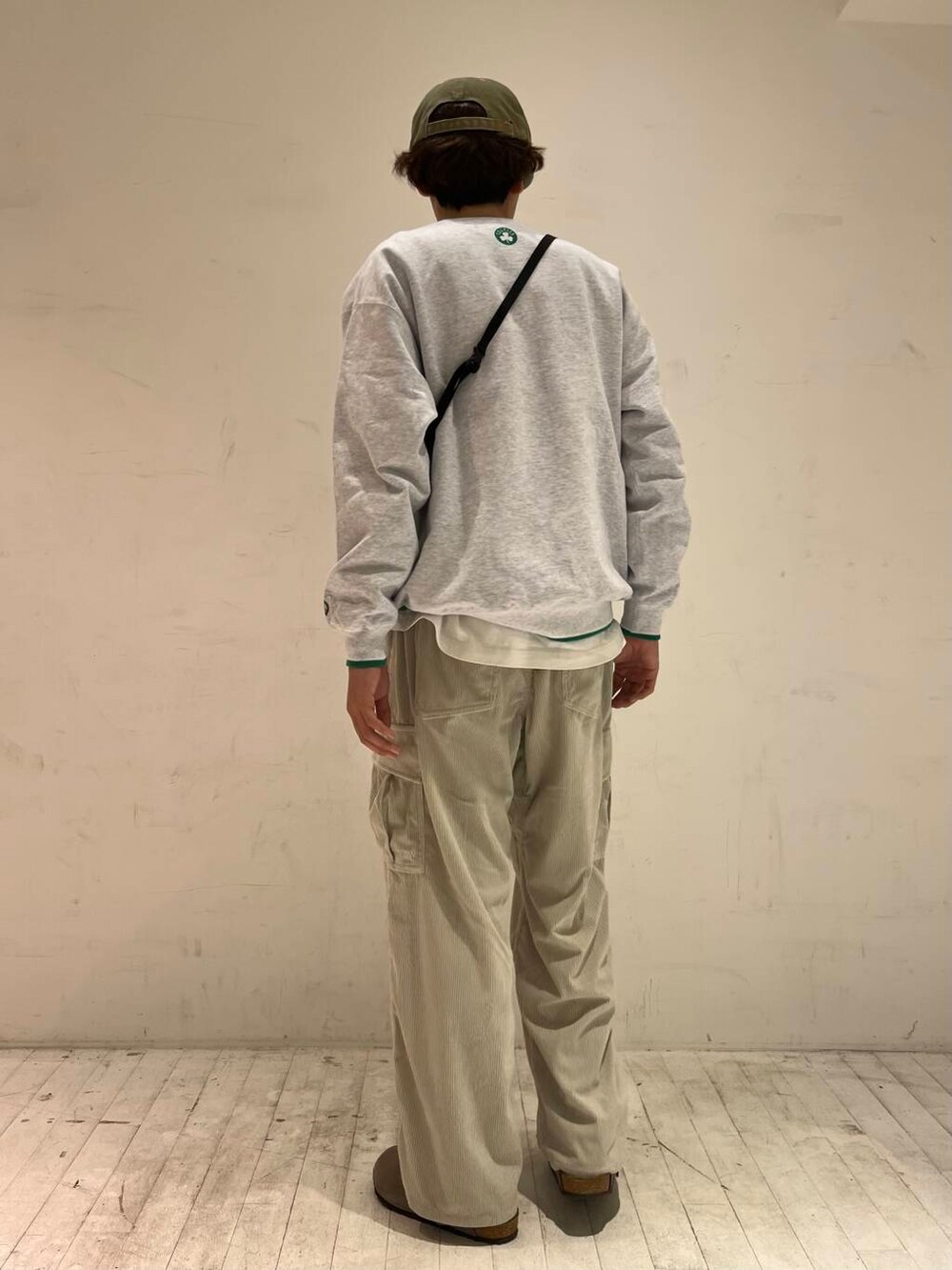 グリーン系のスウェット、ホワイト系のその他パンツ、ブラック系のショルダーバッグを着用したメンズの秋コーディネートの3枚目の写真