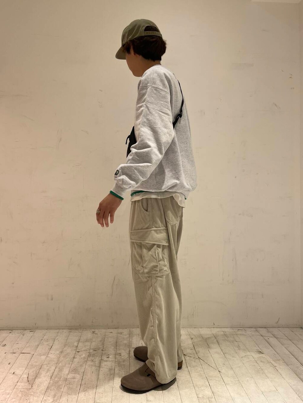 グリーン系のスウェット、ホワイト系のその他パンツ、ブラック系のショルダーバッグを着用したメンズの秋コーディネートの2枚目の写真